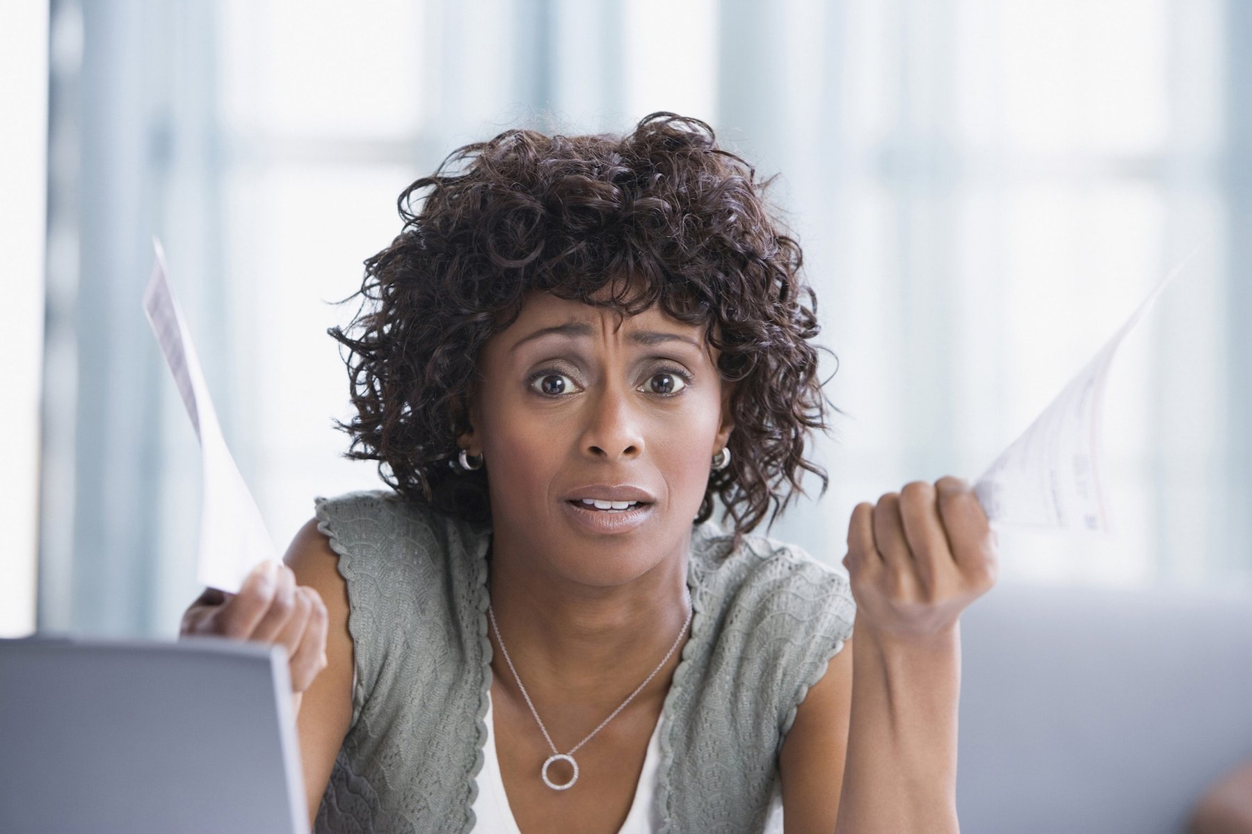 Woman reviewing bills while exploring affordable consumer loan options.